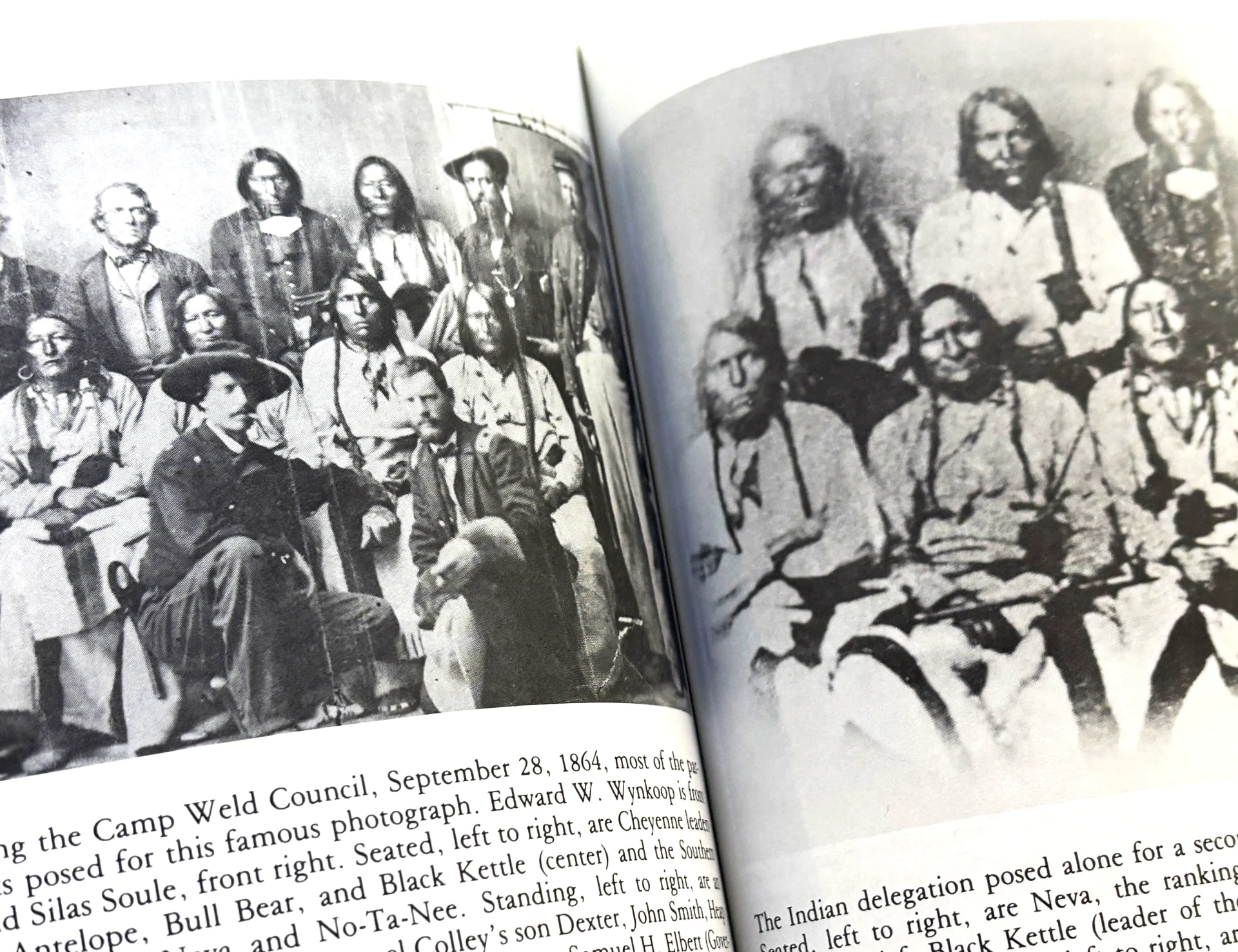 Open history book pages reproducing the iconic 1864 Camp Weld council photograph